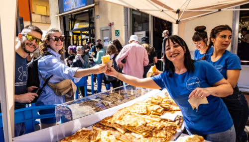 passaggio-da-una-mano-all-altra-di-una-tipica-focaccia-di-recco-in-un-truck-food-allestito-per-la-sagra