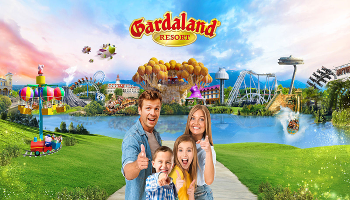 famiglia-che-mostra-il-pollice-e-sullo-sfondo-il-parco-divertimenti-di-gardaland